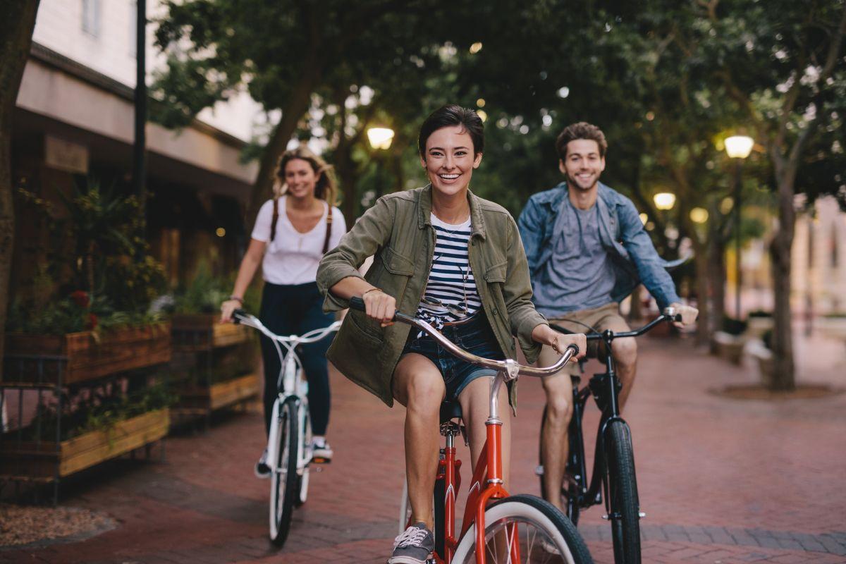 Drei junge Menschen fahren auf ihren Fahrrädern durch die Straßen von Berlin