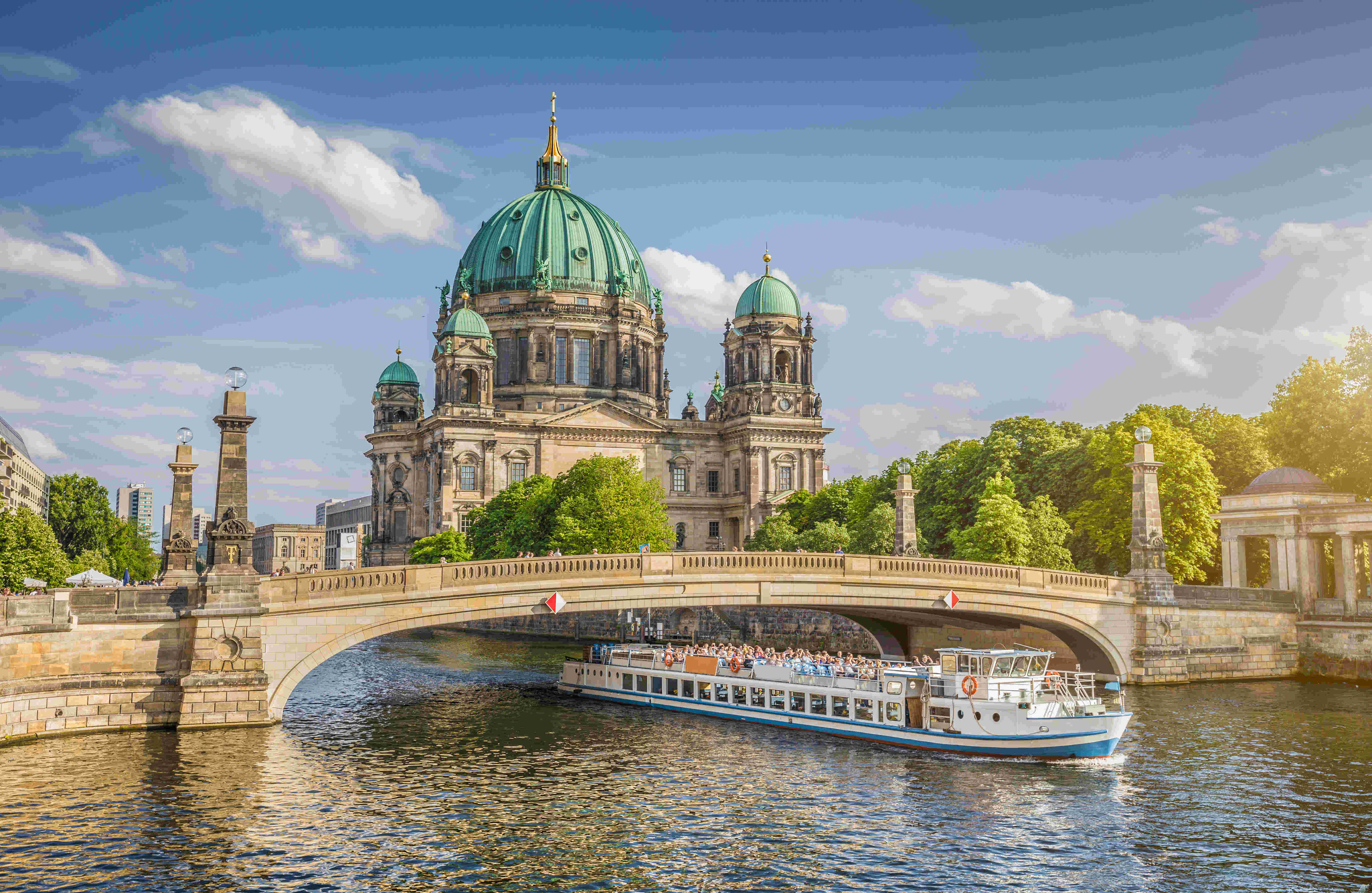 Menschen erleben eine Bootstour auf der Spree mit Blick auf den Berliner Dom