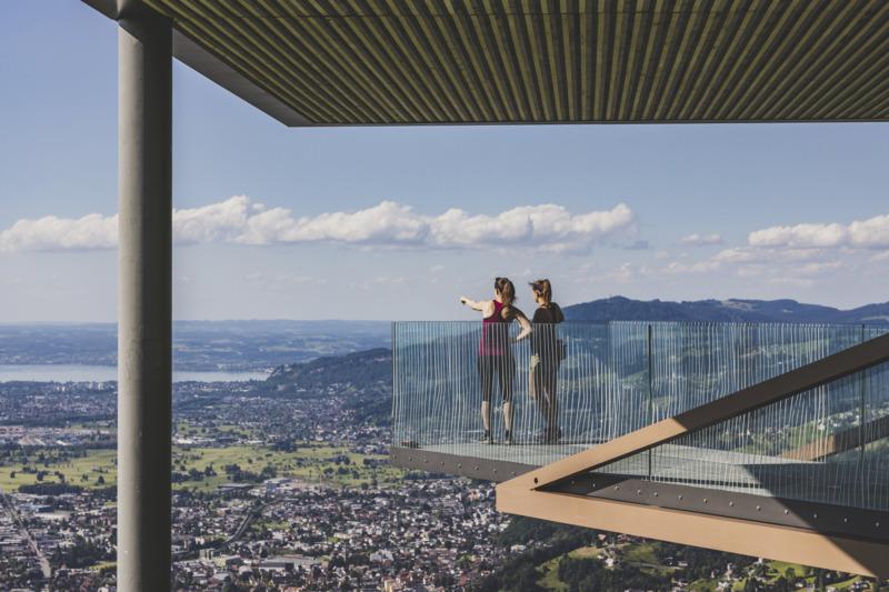 Zwei junge Frauen stehen auf der Aussichtsplattform Karren bei Dornbirn und zeigen auf etwas