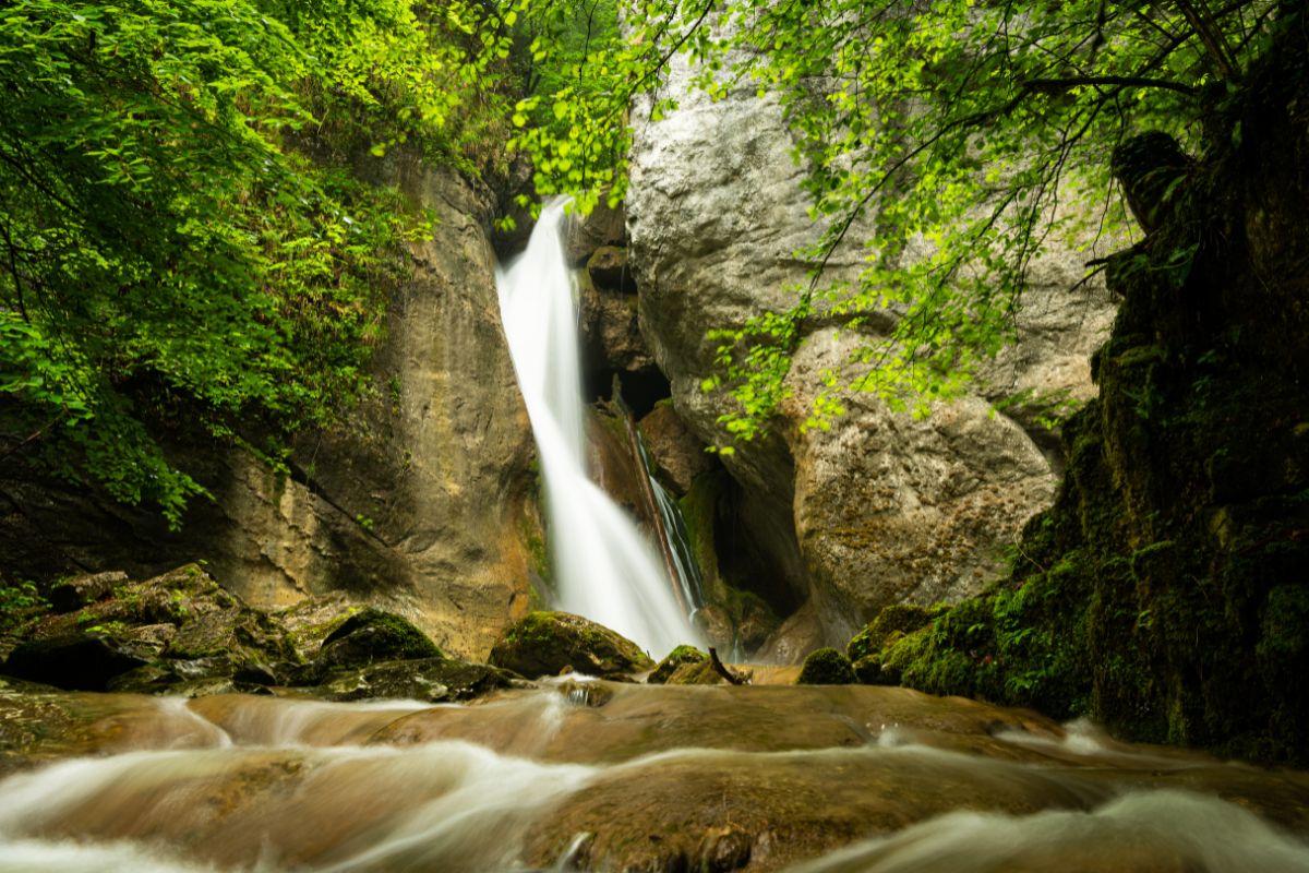 Der Rinnberger Wasserfall, umgeben von Felsen und Bäumen, als Erlebnis bei Steyr
