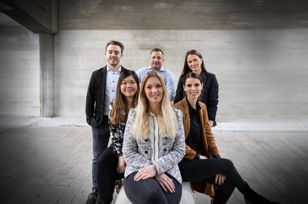 Sympathisches Bild von 6 lächelnden Personen in Businesskleidung